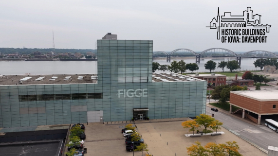 A grey building with FIGGE letters on the front and the Mississippi River behind the building.