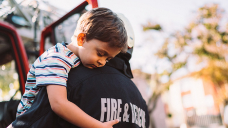 A firefighter carries a young boy to safety