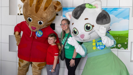 Adult woman and young boy posing with live-action Daniel Tiger and Katerina Kittycat