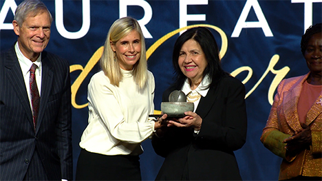 Dr. Mariangela Hungria stands on stage to accept the award.