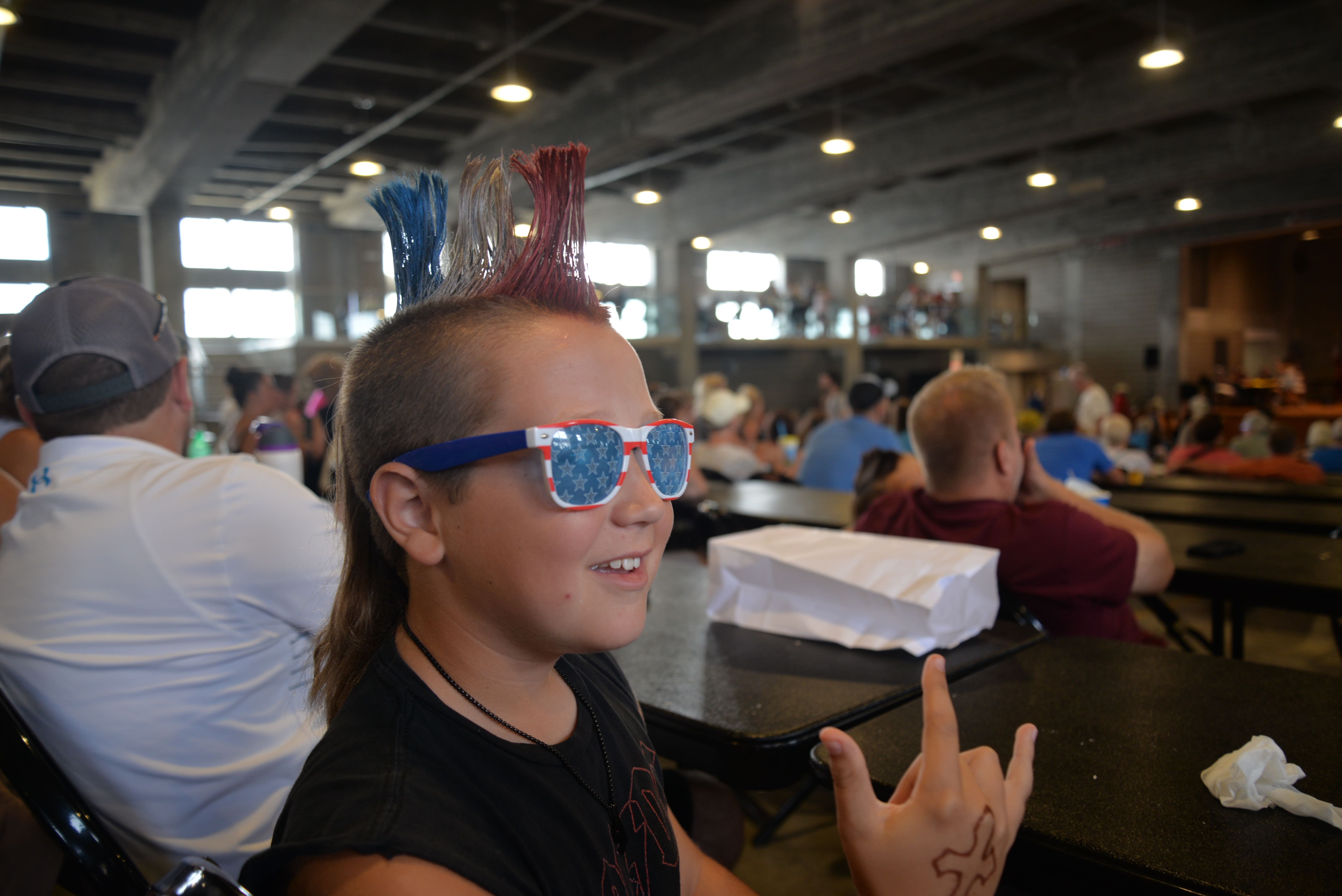 Young participant in mullet contest wearing sunglasses