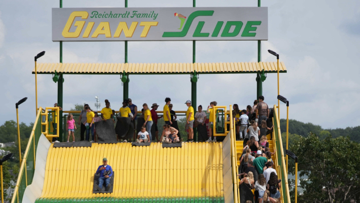 People riding down the Giant Slide at the Fair