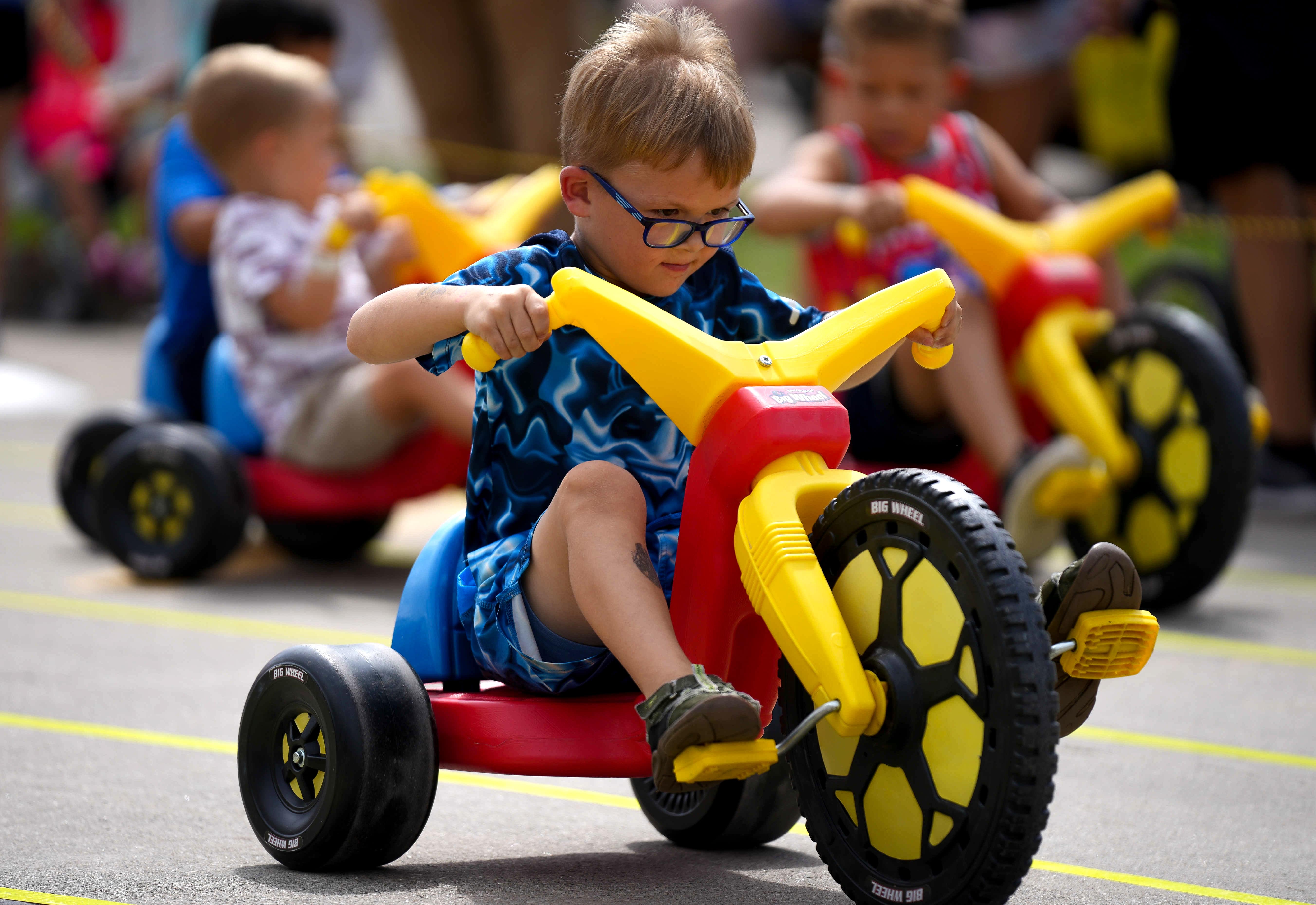 Children enjoying Iowa Parks and Recreation Day on big wheels at the Fair. 