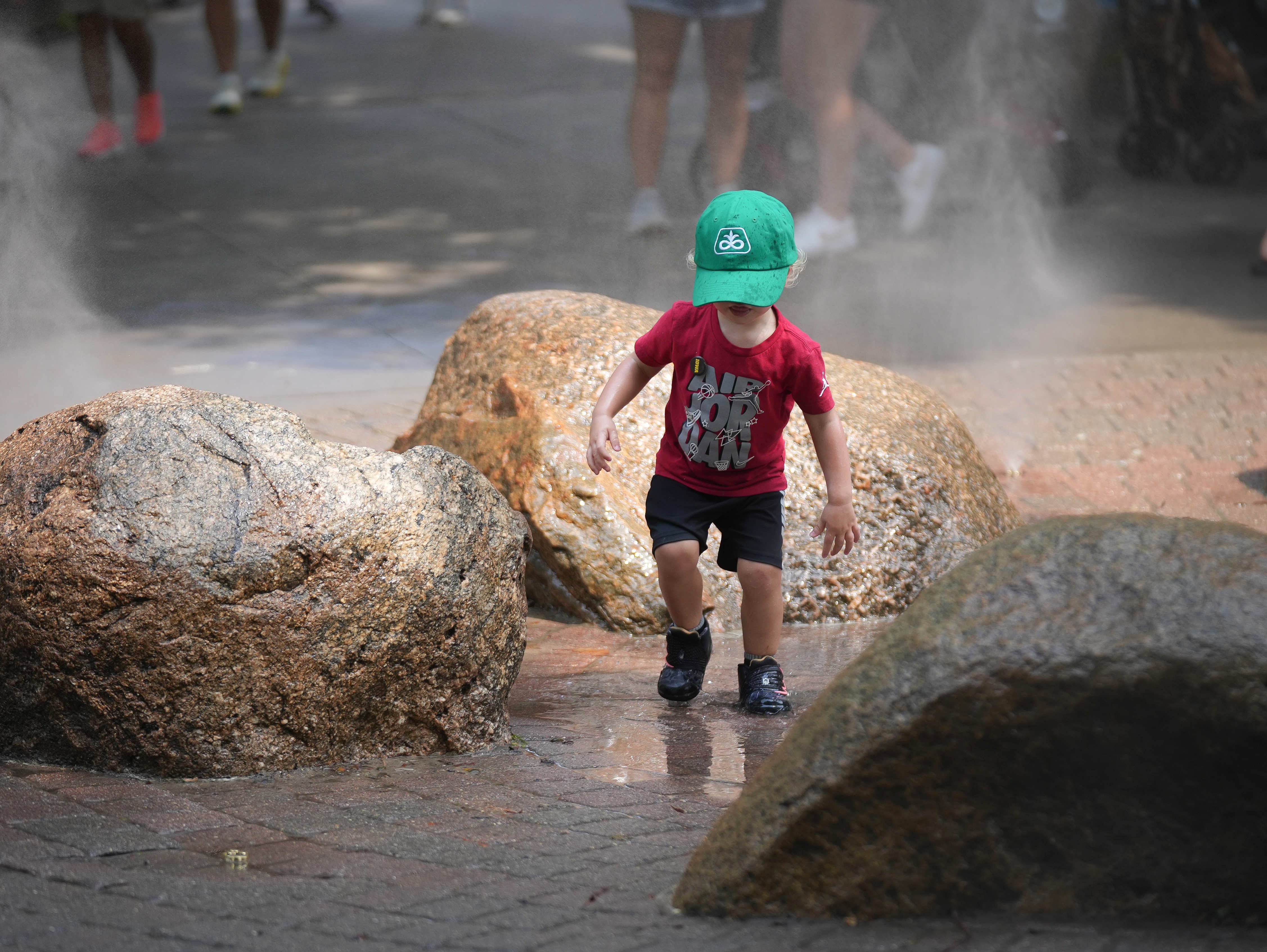 As the temperatures begin to rise again, young fairgoers enjoy the spraying water outside.