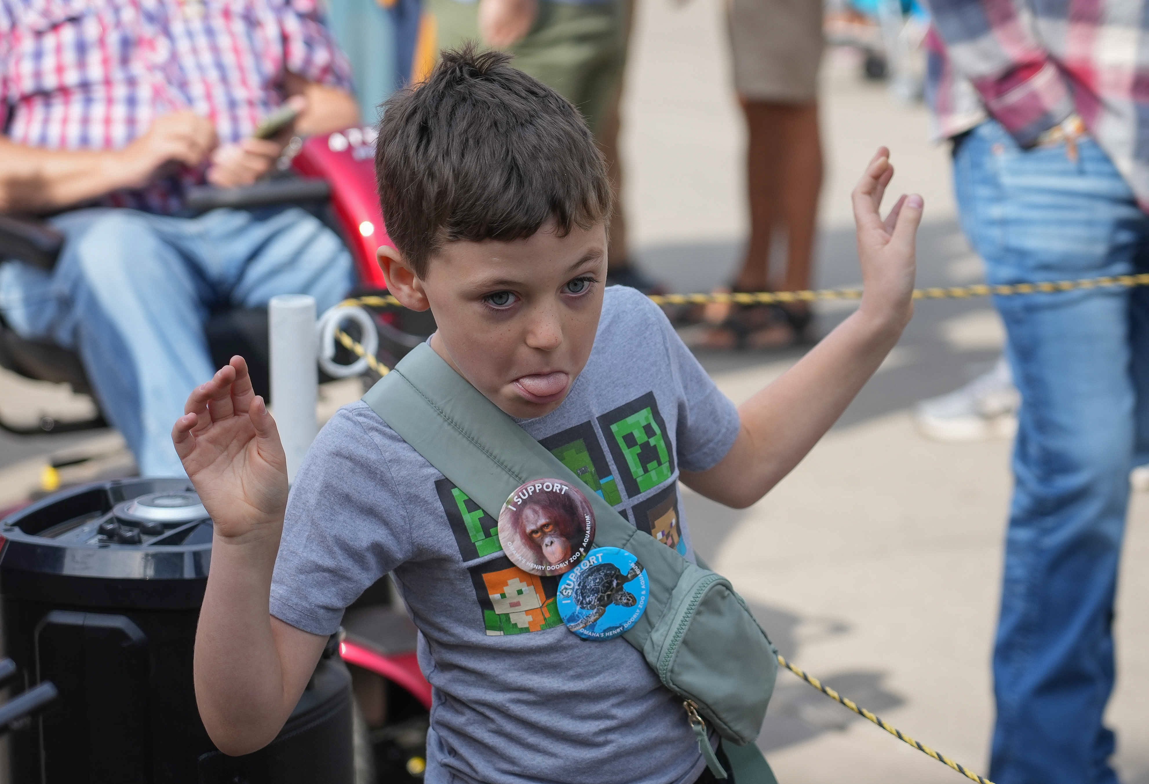 Young boy making a silly face in a crowd. 