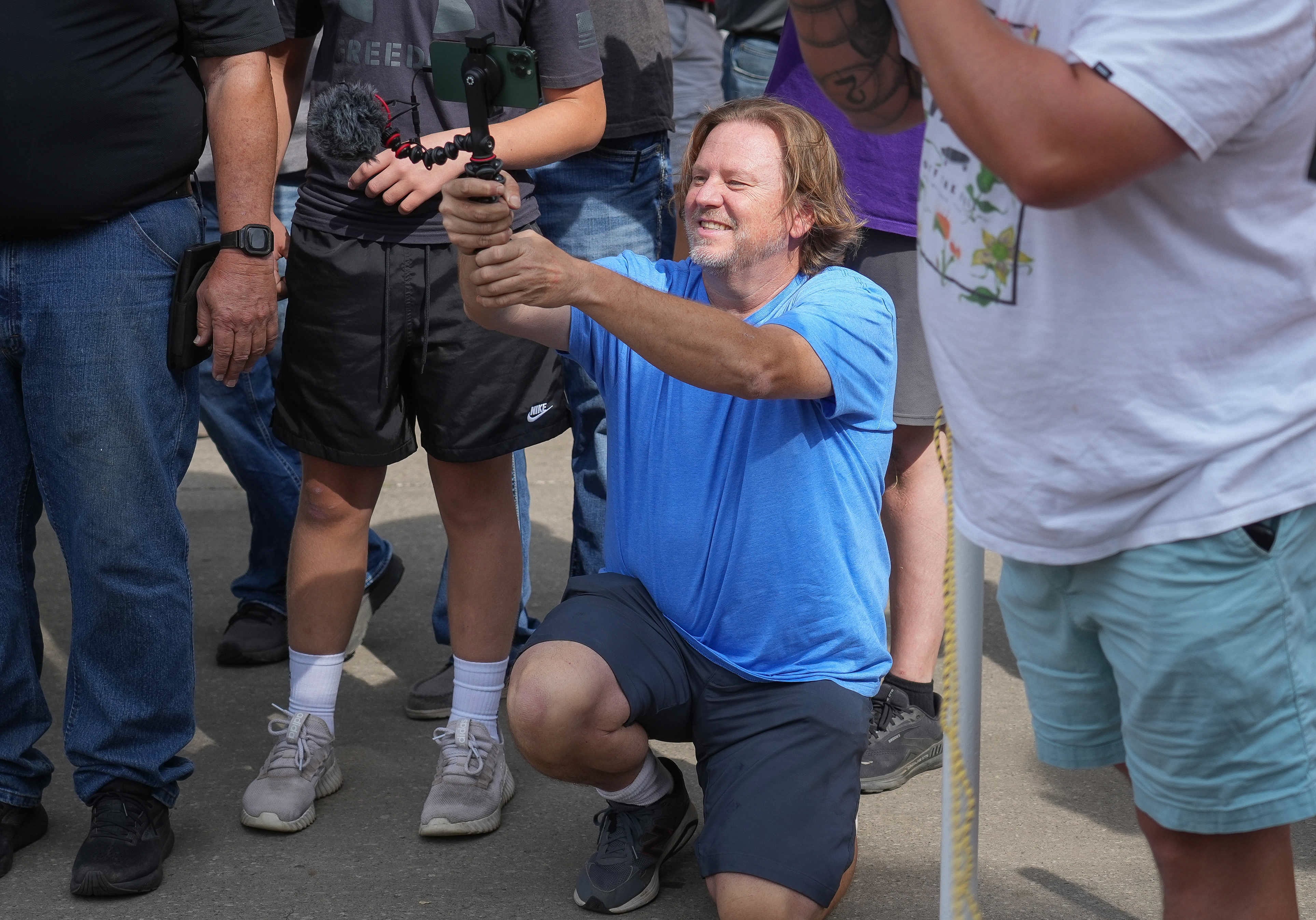 Producer kneeling with a camera in hand at the big pumpkin contest