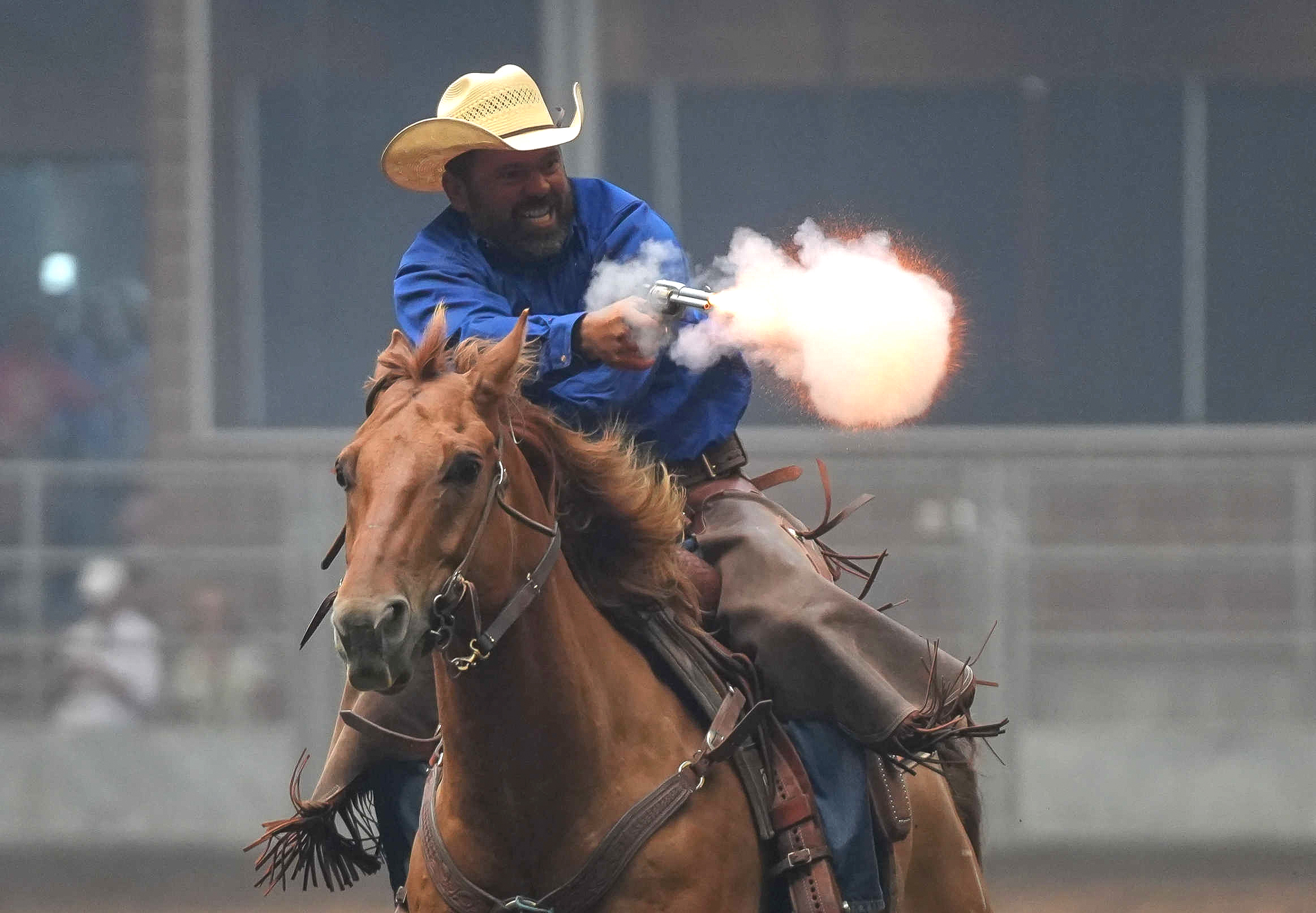 Rider shooting his gun at the targets while mounted on a horse. 