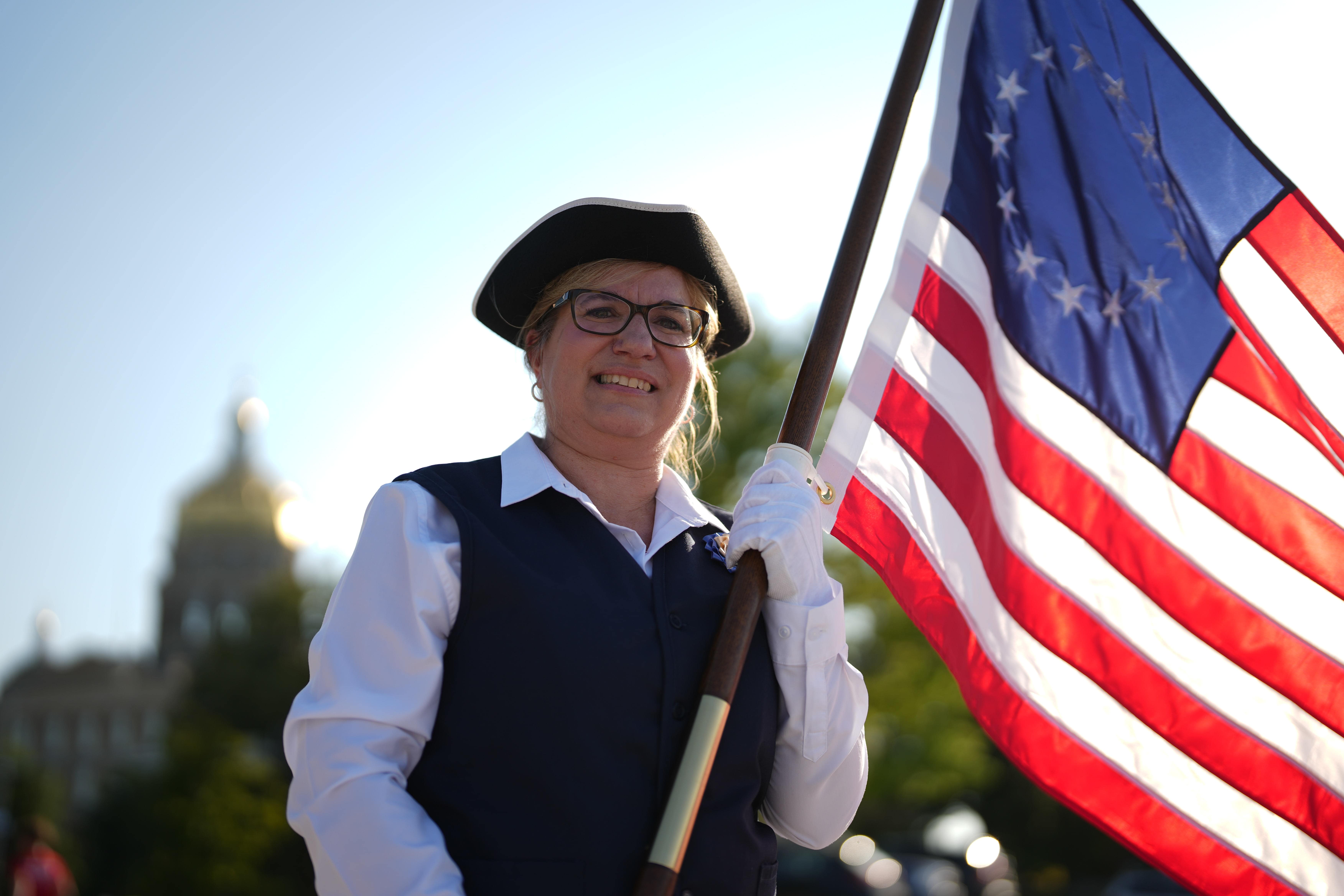 Daughters of the American Revolution in cosplay and holding the American flag.