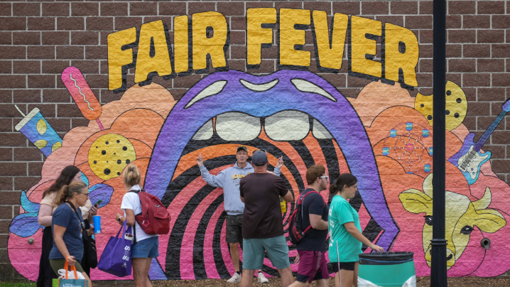 Small crowd standing in front of a new Fair Fever mural