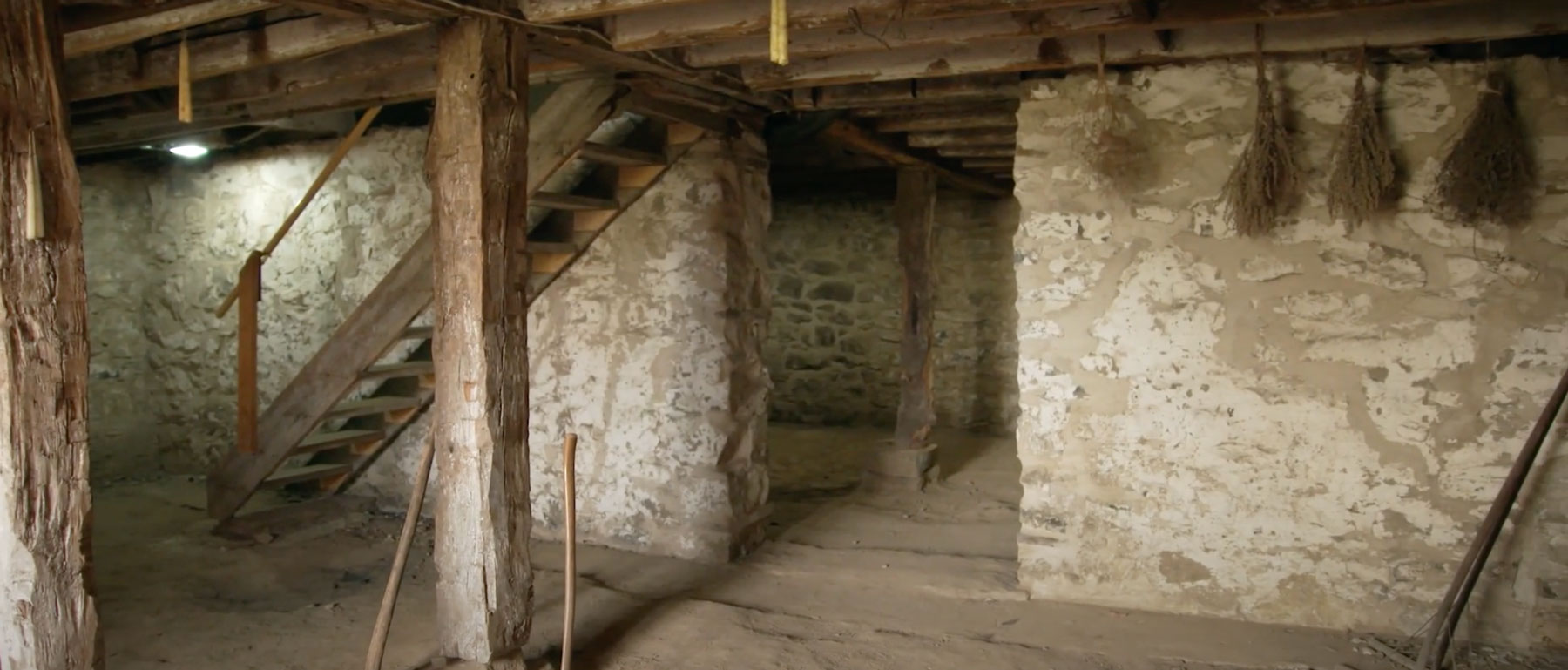 A basement made of limestone walls and hand cut timber.