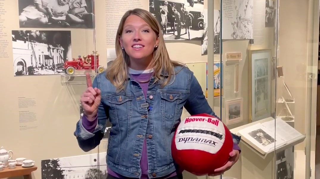 Abby Brown stands in front of information cases at the Hoover Museum