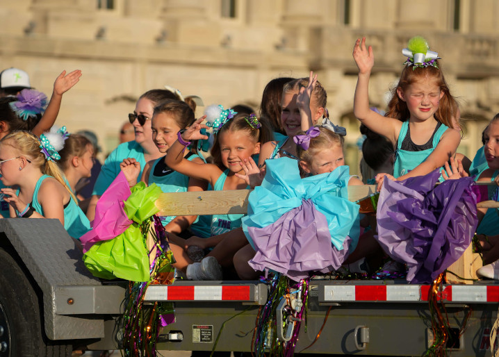 Young dancers on a float waving to the crowd at the Iowa State Fair parade