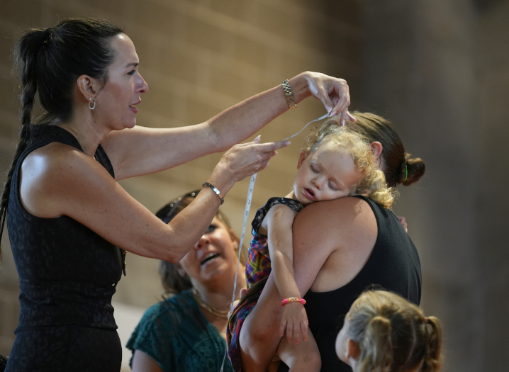 A young contestant in the ponytail contest sleeps through the measurement during the ponytail, braids and mullet contest at the Iowa State Fair.