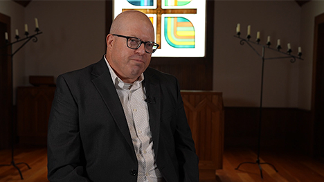 John Torpy, producer of The Pope's Visit to Iowa, sits in front of the Church of the Land alter at Living History Farms.