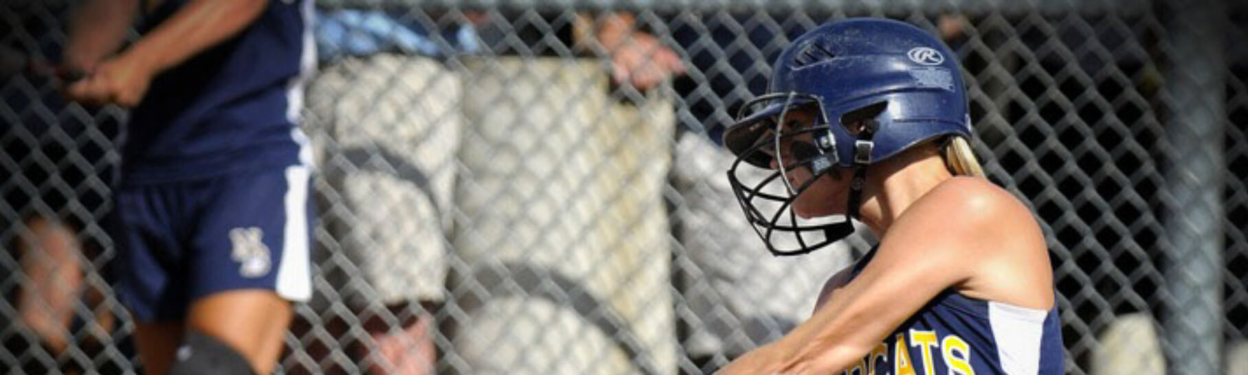 Softball player swinging her bat