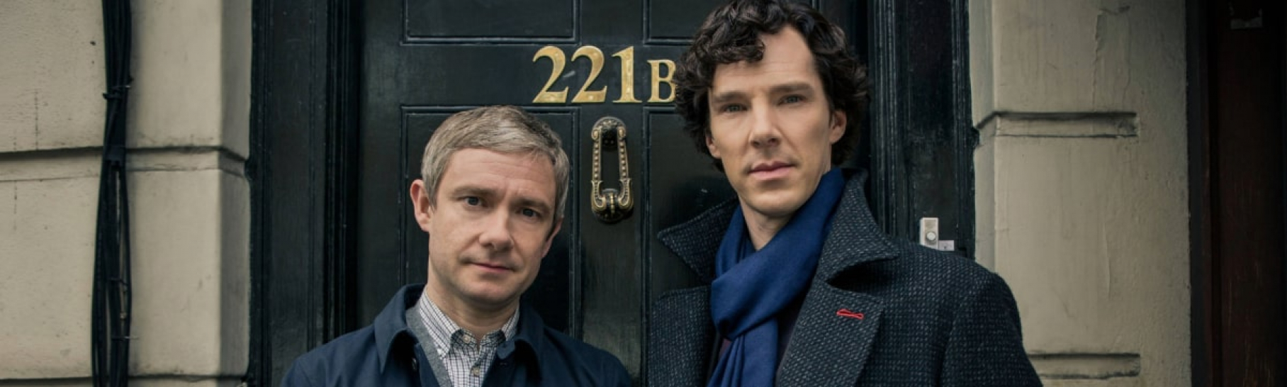 Sherlock Holmes and Dr. Watson standing in front of a door