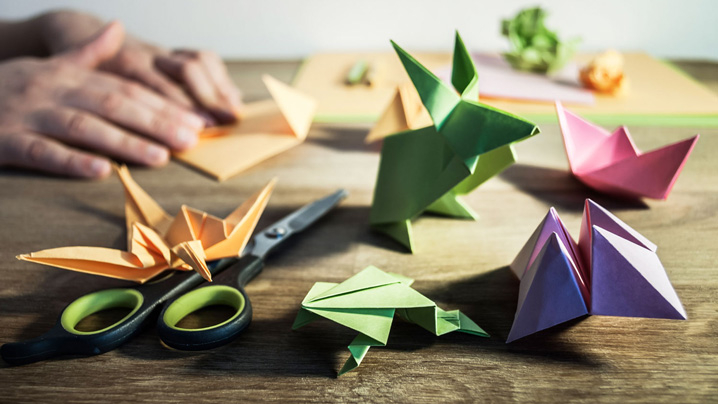 Scissors and animals made of paper sit on a table.