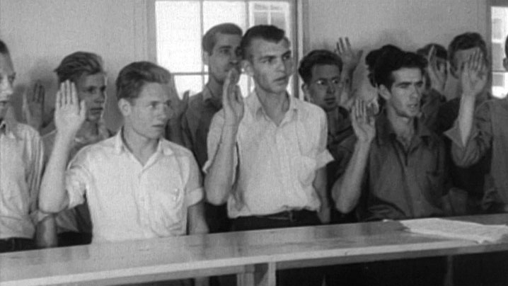 Young men raising their right hands in an oath of service.