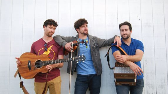 Three men posing for the camera with instruments.