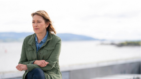 Annika sits along the shore.