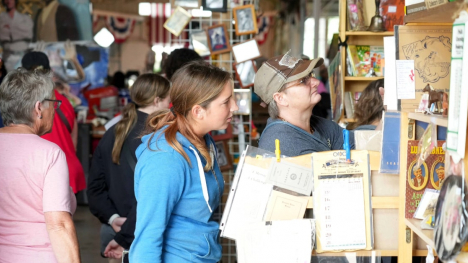 Fairgoers of all ages rummaging through antiques and collectibles in Pioneer Hall