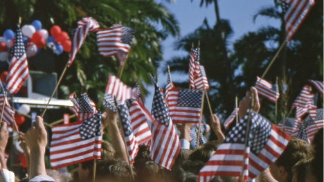 small American flags being waved in an outdoor space