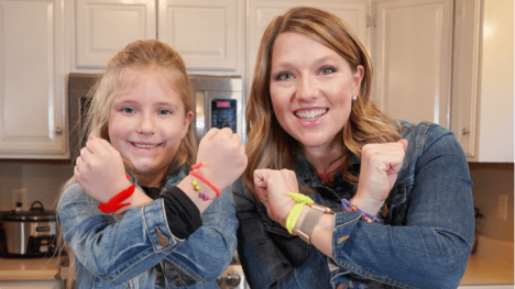 Host Abby Brown and her friend Ivy holding up frirendship bracelets they made together.