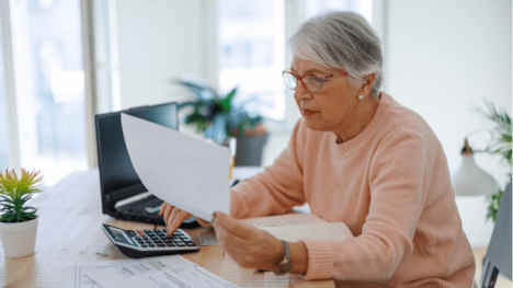 Older woman sitting at a table doing taxes