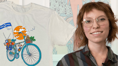 Artist Maddy Fusco alongside her custom illustrated t-shirt she designed for Iowa PBS featuring a bicycle