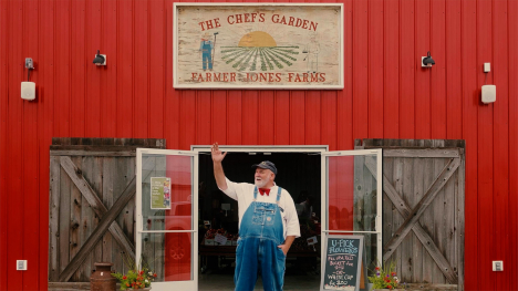 Farmer Lee Jones waves from the entrance of his barn
