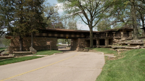 A two-story stone and wood structure stretches across the road running through the park