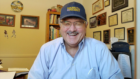 A smiling Tim Dufault wears his Market to Market hat in his office.