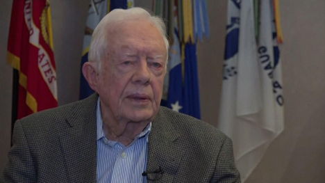 Jimmy Carter in front of some flags.